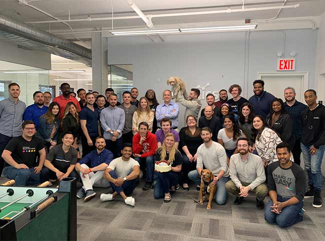 Large group photo of Recruitics team in their break room