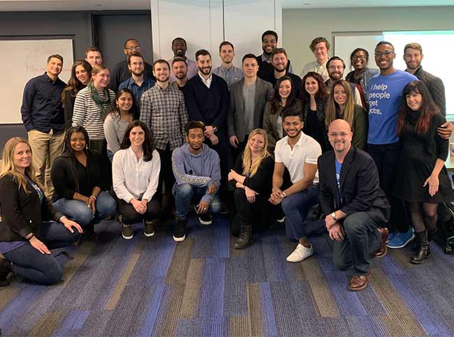 Large group photo of Recruitics team in their break room